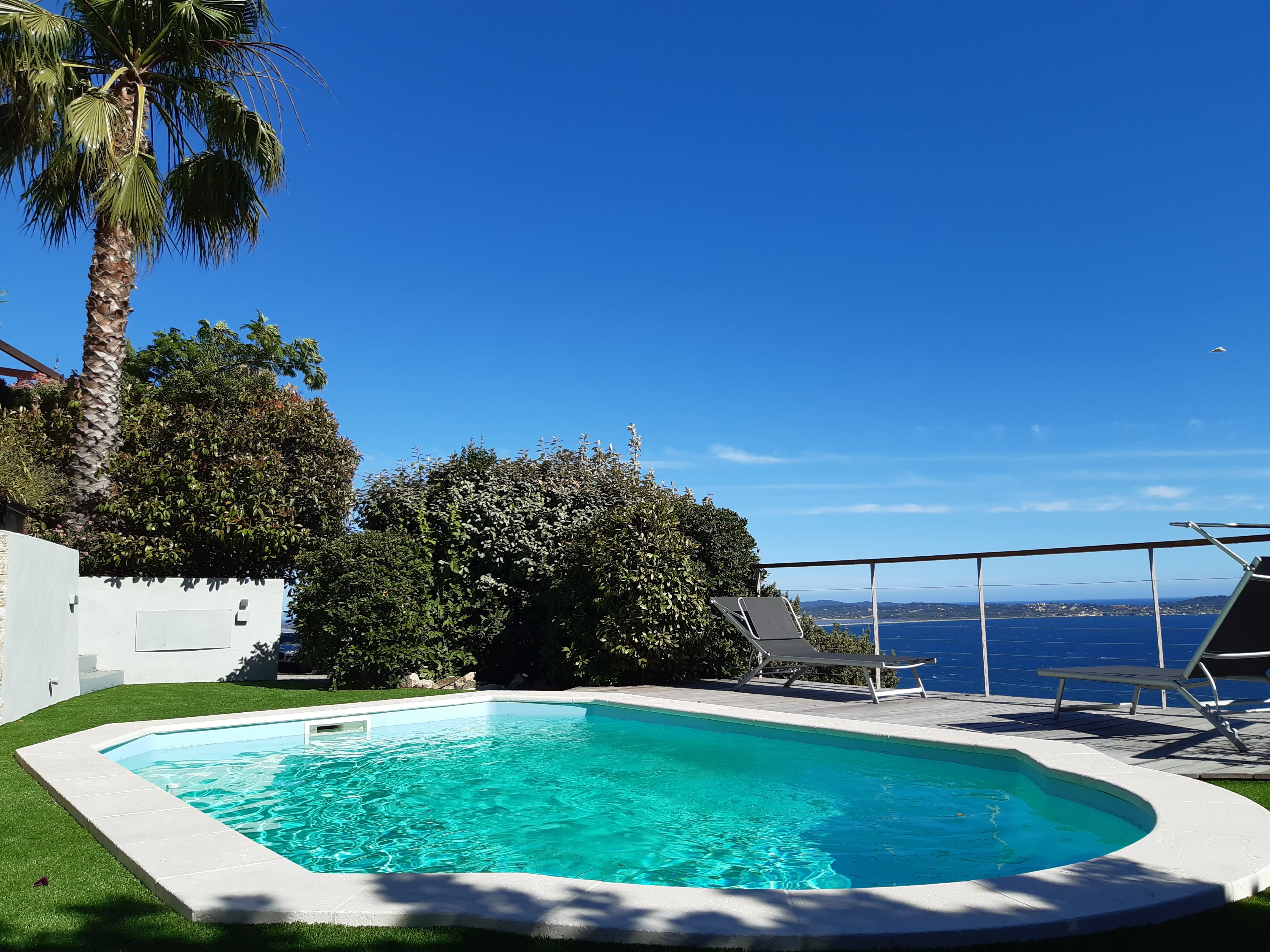 Vue du jardin sur la piscine et mer